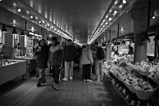 People walking through a busy market hall.